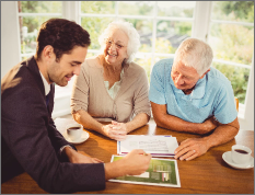 businessman-showing-sheets-senior-couple-home